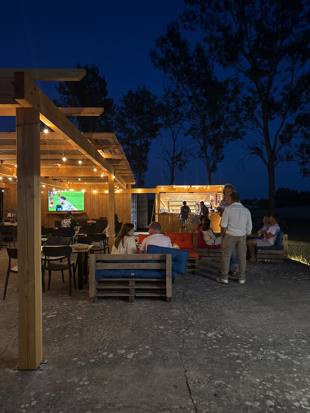 Retransmission d'un match sur grand écran à la guinguette en soirée