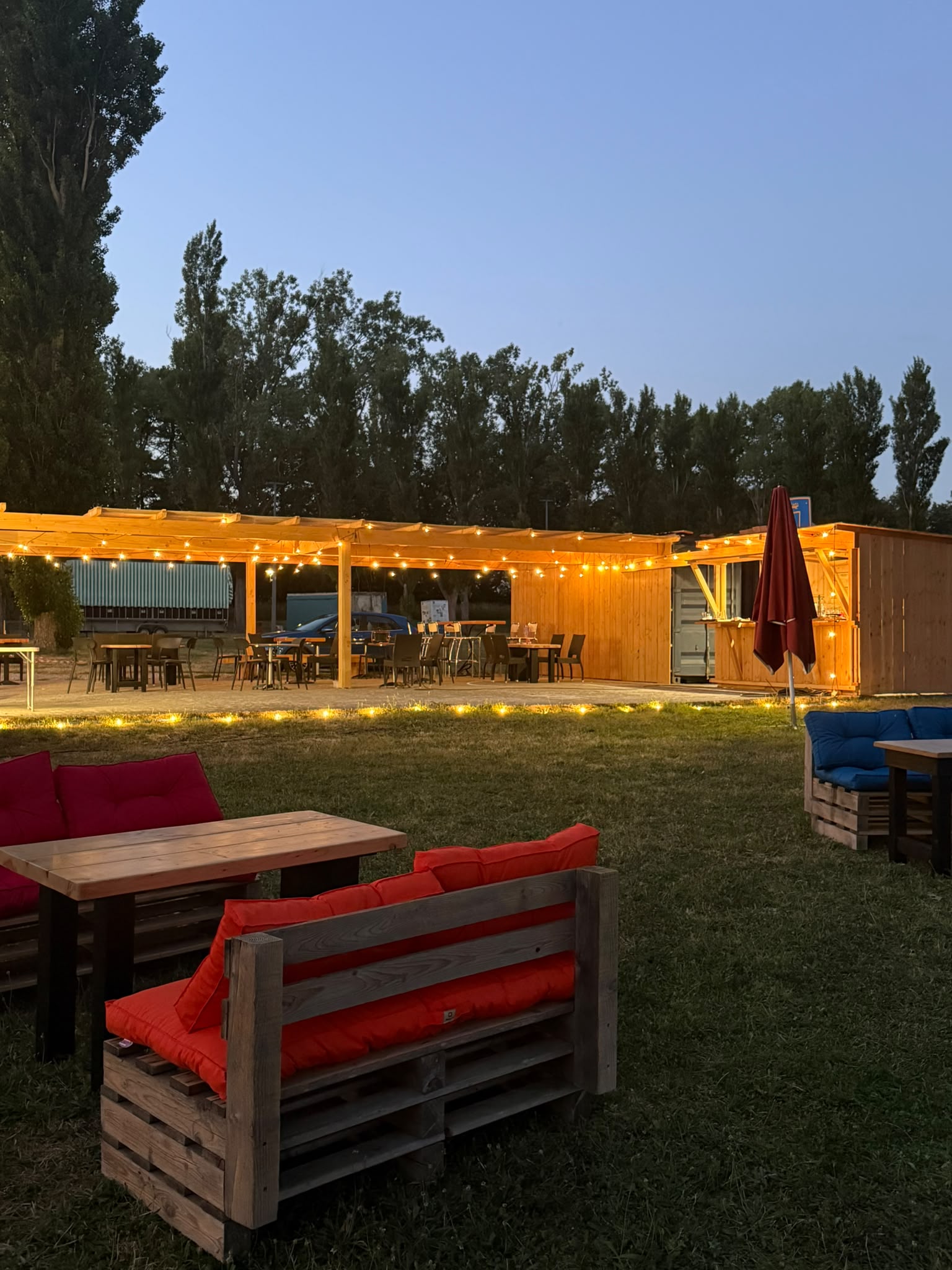 Terrasse de la Guinguette de Nini illuminée de guirlandes à la tombée de la nuit